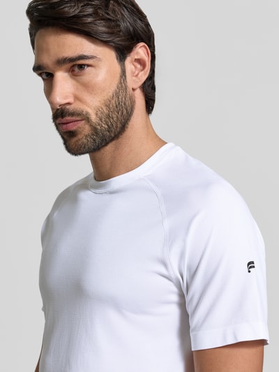 Männermodel trägt weißes Regular Fit T-Shirt mit Logo-Print Modell 'The Training Day' von Fabletics, Nahaufnahme Oberkörper