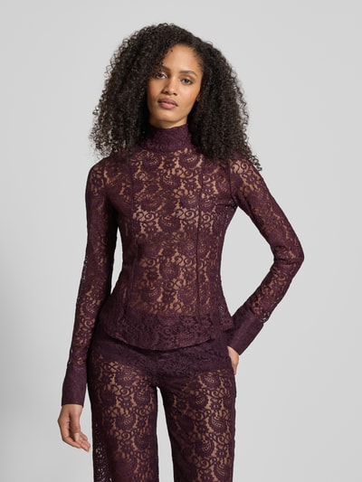 Frauenmodel trägt Blusenshirt mit Stehkragen Modell 'GRACE' von Mango in Aubergine, semitransparenter Material-Mix, Nahaufnahme Oberkörper.