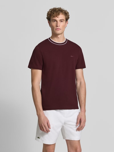 Männermodel trägt Regular Fit T-Shirt aus Baumwoll-Mix von Lacoste in bordeaux mit weißen Shorts, Heren T-Shirt, Ganzkörperansicht von vorne