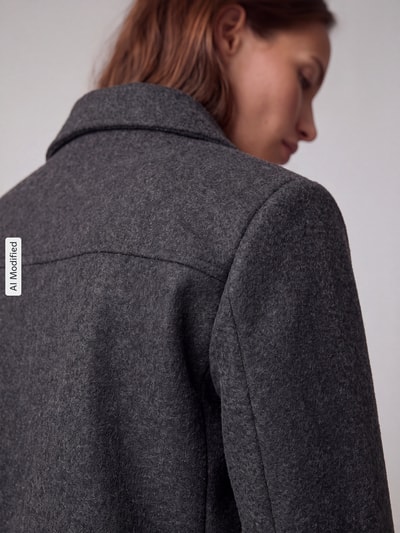 Frauenmodel trägt Regular Fit Blouson mit Umlegekragen Modell 'SAFIR' von VERO MODA, dunkles Grau, weiche Textur, Nahaufnahme Rücken, Damen Bomberjacke / Blouson, KI-modifiziertes Bild.