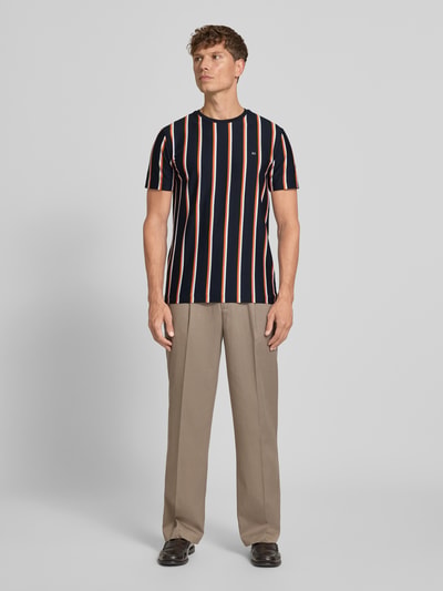 Mężczyzna model nosi Regular Fit T-Shirt mit Logo-Stitching von Christian Berg Men z bawełny, krój regular fit, wyhaftowane logo, okrągły dekolt, długość tyłu w rozmiarze M: 71 cm. Ganzkörperansicht von vorne.