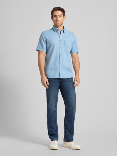 Männermodel trägt Regular Fit Freizeithemd aus reiner Baumwolle von Tom Tailor, Optik: Unifarben, Struktur, Kentkragen, durchgehend Knopfleiste, Kurzarm, Brusttasche, Rückenpasse, Materialverarbeitung: Washed, Ganzkörperansicht von vorne.
