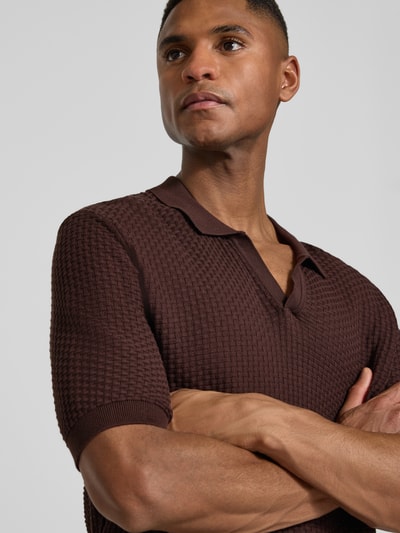 Männermodel trägt Regular Fit Poloshirt aus reiner Baumwolle Modell 'H-Natalo' von BOSS in brauner Flechtoptik, Nahaufnahme Oberkörper.