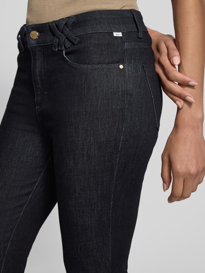 Frauenmodel trägt Flared Fit Jeans im 5-Pocket-Design Modell 'Shakira' von BRAX, dunkler Baumwoll-Mix, Detailaufnahme Hüfte.