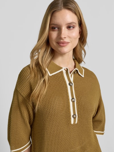 Frauenmodel trägt Strickshirt mit Polokragen und Knopfleiste von Style Icon Collection in Olivgrün, grob gestrickt, reine Baumwolle, Nahaufnahme Oberkörper.