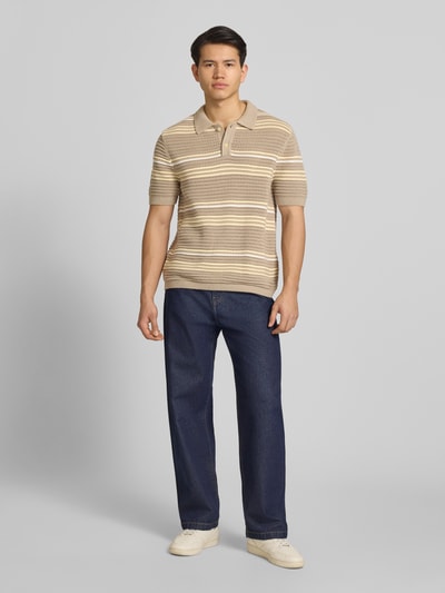 Männermodel trägt Relaxed Fit Poloshirt aus reiner Baumwolle Modell 'LAGUNA' von Levi's® in Strickoptik, gestreift, Ganzkörperansicht von vorne.