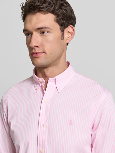 Männermodel trägt Freizeithemd mit Knopfleiste von Polo Ralph Lauren, rosa-weiß gestreift, Baumwoll-Elasthan-Mix, Nahaufnahme Oberkörper, Regular Fit, Button-Down-Kragen, Label-Stitching, Größe M Rückenlänge 84 cm, Schulterbreite 47 cm, Ärmellänge 66 cm.