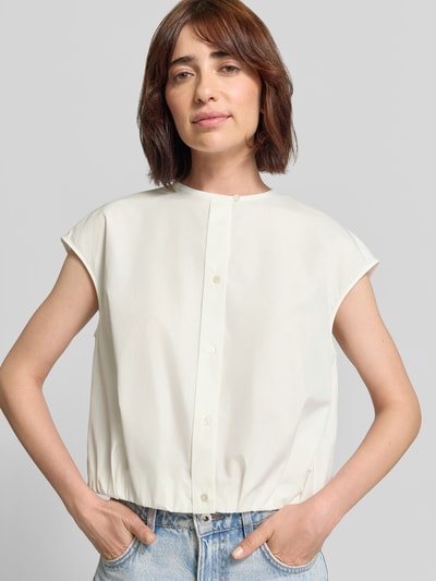 Frauenmodel trägt Boxy Fit Kurzarmbluse aus reiner Baumwolle Modell 'GELATINA' von Weekend Max Mara in Creme, klare Linien, matte Textur, Damen Kurzarmbluse von Weekend Max Mara, Nahaufnahme Oberkörper.