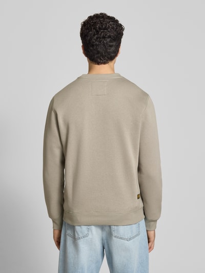 Männermodel trägt Sweatshirt mit Rundhalsausschnitt und Label-Stitching von G-Star Raw aus Baumwoll-Mix in Sand, Regular-Fit, Rückenlänge 67 cm, Ärmellänge 66 cm, Ganzkörperansicht Rückansicht.