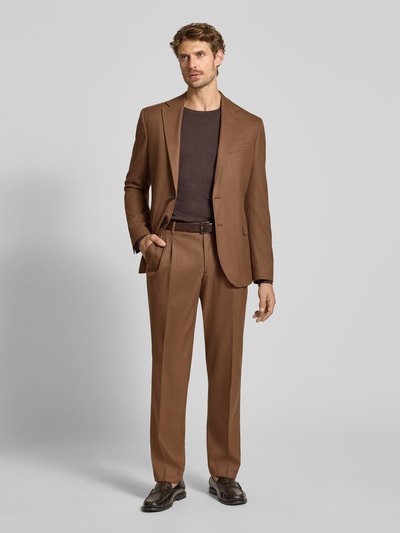 Męski model nosi Regular Fit Sakko mit Viskose-Anteil von MCNEAL, elastyczna mieszanka materiałów, Kołnierz z połami, listwa z 2 guzikami, Kieszenie z patką, brązowy kolor, Długość tyłu w rozmiarze 50: 76 cm, Szerokość ramion w rozmiarze 50: 40 cm, Długość rękawów w rozmiarze 50: 66 cm, widok całej sylwetki z przodu.