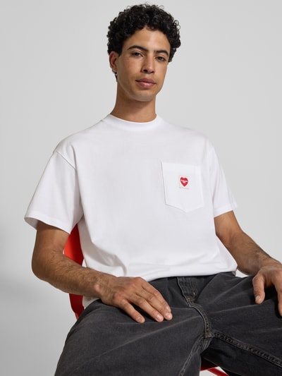 Männermodel trägt T-Shirt mit Brusttasche und Label-Patch von Carhartt Work In Progress, reine Baumwolle, weiß, Modern Fit, Nahaufnahme Oberkörper