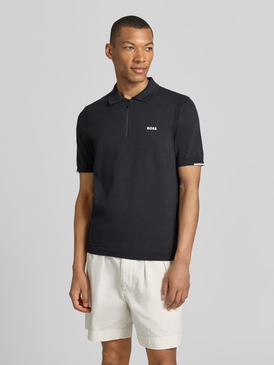 Männermodel trägt Regular Fit Poloshirt aus reiner Baumwolle Modell 'KN_EVER-X' von BOSS Green, Optik: Unifarben, Feinstrick, Label-Applikation, Polokragen, V-Ausschnitt, kurzer Reißverschluss, Kurzarm, gerippte Abschlüsse, Ganzkörperansicht von vorne.