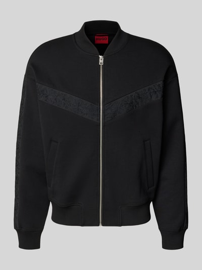 Frauenmodel trägt Oversized Sweatjacke aus Baumwoll-Mix Modell 'DROMZIP' von HUGO, Optik: Unifarben schwarz, Reißverschluss, Logo-Patch, Motiv-Stitching, College-Kragen, Langarm, gerippte Abschlüsse, seitliche Eingrifftaschen, Materialverarbeitung: Sweat, Ganzkörperansicht von vorne.