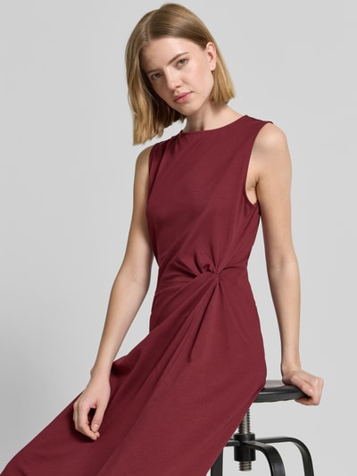 Modelka nosi Tailliertes Freizeitkleid aus Baumwoll-Mix od s.Oliver RED LABEL, kolor jednolity, krój taliowany, długość midi, dekolt łódka, drapowanie w talii, szerokie ramiączka, bez rękawów, dół rozkloszowany, materiał bawełniany miks, jersey, widok z przodu, zbliżenie na górną część ciała.