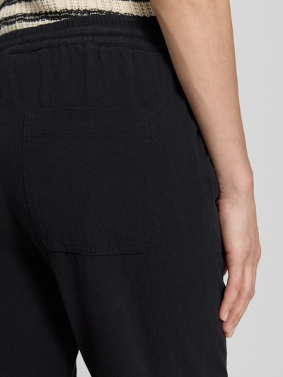 Frauenmodel trägt Hose mit elastischem Bund und Tunnelzug Modell 'Cissie' von Soyaconcept aus Reine Baumwolle, Relaxed-Fit, Detailaufnahme Rückansicht.