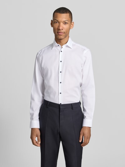 Männermodel trägt Regular Fit Business-Hemd mit Kentkragen von Christian Berg Men aus Reine Baumwolle, Ganzkörperansicht von vorne. Rücklänge 78 cm, Schulterbreite 47 cm, Ärmellänge 65 cm, Knopfleiste, Sportmanschetten, abgerundeter Saum.