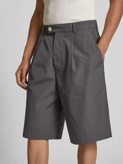 Männermodel trägt Straight Fit Bermuda mit Bundfalten von ANNARR aus Reine Baumwolle, Bundfalten, Gesäßtaschen, Nahaufnahme Oberkörper.