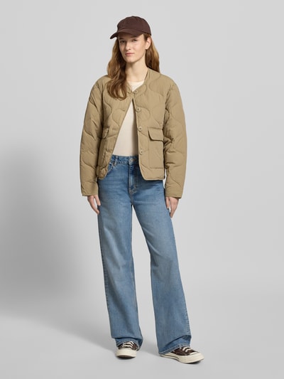 Frauenmodel trägt Steppjacke mit Knopfleiste Modell 'HOPE' von JJXX in Beige, gerade Passform, mit Rundhalsausschnitt und Pattentaschen, Ganzkörperansicht von vorne. Rückenlänge bei Größe S: 56 cm, Schulterbreite: 45 cm, Brustweite: 51 cm, Ärmellänge: 56 cm.