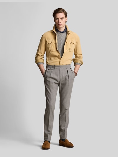 Męski model nosi Suede-Hemdjacke aus Ziegenwildleder od Polo Ralph Lauren, kolor jednolity, krój prosty, widok całej sylwetki z przodu. Szerokość w rozmiarze M: 41 cm, długość tyłu: 63 cm, szerokość ramion: 45 cm, długość rękawa: 66 cm, kieszenie z patkami na piersi, kołnierz wykładany, materiał: zamsz kozi.