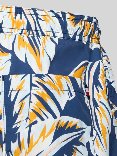 Produktfoto, Regular Fit Badehose mit Logo-Stitching von Tommy Hilfiger für Herren, Optik:Allover-Muster, Gesäßtasche, elastischer Bund mit Tunnelzug, Eingrifftaschen, Textur aus glattem Stoff, leuchtende Farben Blau, Weiß und Orange.