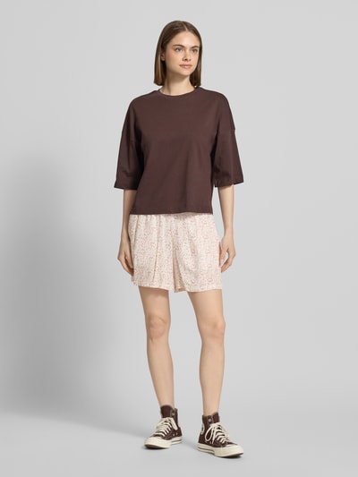 Frauenmodel trägt Regular Fit Shorts aus reiner Viskose Modell 'BARRI' von Pieces mit Florales-Allover-Muster, Bundabschluss: Elastisch, seitliche Eingrifftaschen, Material: reine Viskose, Ganzkörperansicht von vorne.