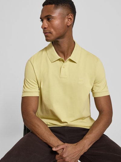 Männermodel trägt Regular Fit Poloshirt aus Baumwoll-Mix Modell 'PASSENGER' von BOSS Orange, unifarben, Nahaufnahme Oberkörper.