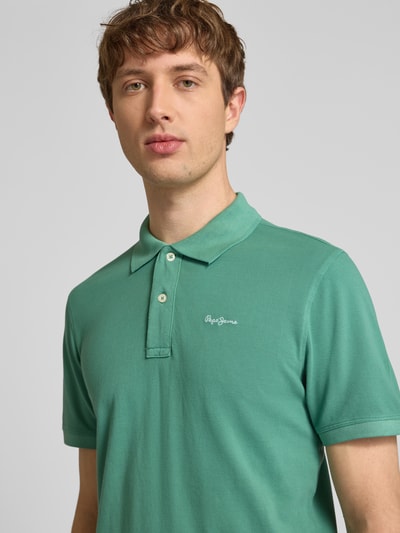 Männermodel trägt Regular Fit Poloshirt aus reiner Baumwolle Modell 'OSCAR' von Pepe Jeans, Optik: Unifarben, Nahaufnahme Oberkörper.