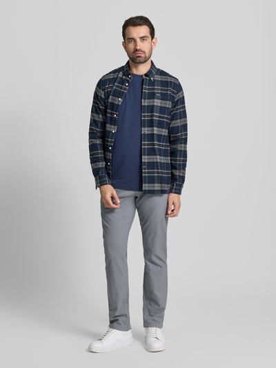 Mężczyzna nosi Slim Fit Stoffhose mit Gesäßtaschen von MCNEAL, bawełna z domieszką, krój slim fit, szare, widok całej sylwetki z przodu. Szerokość w rozmiarze 50: 46 cm, długość nogawki: 84 cm.
