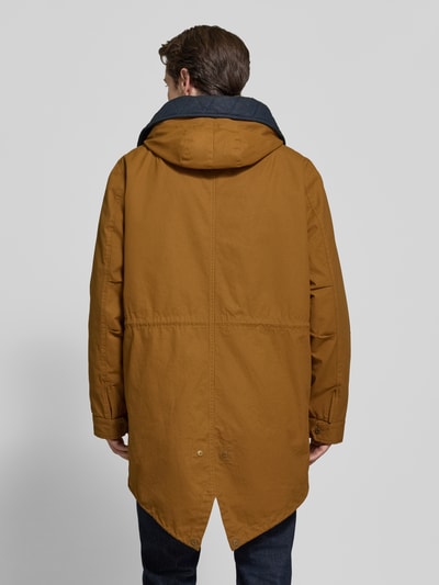 Männermodel trägt Regular Fit Mantel aus reiner Baumwolle Modell 'FISHTAIL' von Scotch & Soda in Braun mit Kapuze, Rückenansicht, Kontext: Herren Mantel, Regular Fit, Kapuze mit Tunnelzug, Eingrifftaschen, Maße Größe M