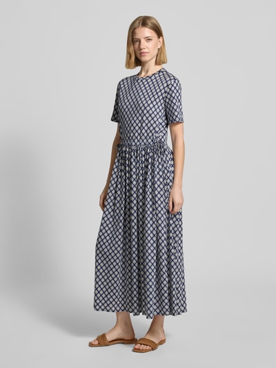 Frauenmodel trägt Tailliertes Freizeitkleid aus reiner Baumwolle Modell 'FASCINO' von Weekend Max Mara, Optik:Allover-Muster, Passform tailliert, Midi-Länge, Rundhals, Raffung, Ärmelform: Kurzarm, gerader Saum, Struktur leicht, Stoff wirkt weich, ganz in Blau- und Weißtönen, Ganzkörperansicht von vorne.