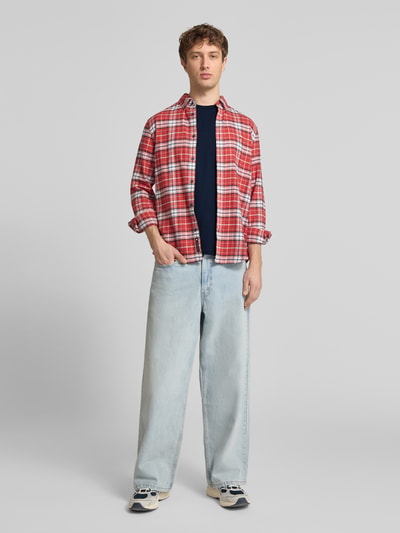 Männermodel trägt Slim Fit T-Shirt aus reiner Baumwolle von Tommy Jeans in Optik: Unifarben, Passform: Slim-Fit, Label-Print, Logo-Stitching, Rundhals, Ärmelform: Kurzarm, Material: Reine Baumwolle, Ganzkörperansicht von vorne.