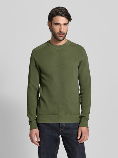 Männermodel trägt Slim Fit Pullover in Strick-Optik Modell 'Nordin' von Casual Friday in Olivgrün, Rundhalsausschnitt, Ganzkörperansicht von vorne.