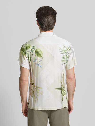 Männermodel trägt Regular Fit Freizeithemd aus Viskose von Guess, florales Muster in Grün und Creme, Ganzkörperansicht Rückansicht. Rückenlänge 70 cm, Schulterbreite 43 cm, Ärmellänge 22 cm, Kentkragen, Knopfleiste.