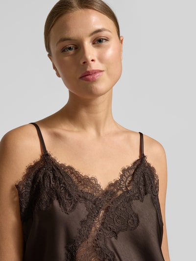 Vrouwenmodel draagt Trägertop met Spitze Model 'Viole' van Neo Noir, materiaalmix met stretch, asymmetrische look, spaghettibandjes, detailopname bovenlichaam.