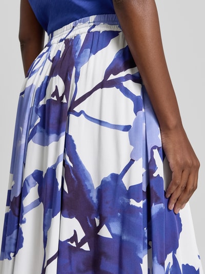 Frauenmodel trägt Midirock aus reiner Viskose mit floralem Allover-Print von Betty Barclay in Weiß und Blau, Nahaufnahme Oberkörper.