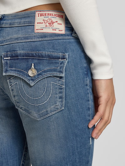 Frauenmodel trägt Flared Jeans Modell 'JOEY' von TRUE RELIGION aus blauem Baumwoll-Mix mit Stretch-Anteil, Nahaufnahme Rückansicht