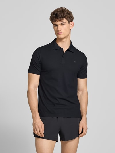 Männermodel trägt Slim Fit Poloshirt mit Logo Modell 'EDMOND' von Ellesse, schwarzer Material-Mix mit Stretch-Anteil, Knopfleiste, Ganzkörperansicht von vorne. Rückenlänge bei Größe M: 63 cm.
