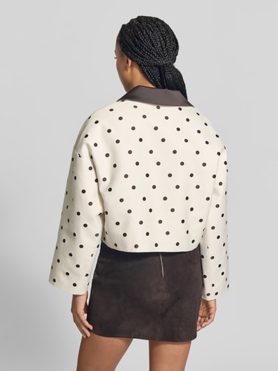 Frauenmodel trägt Damen Jacke aus Baumwoll-Mix von BAUM & PFERDGARTEN mit schwarzen Punkten, gerader Passform, Kontrastkragen, Rückansicht, KI-modifiziertes Bild.