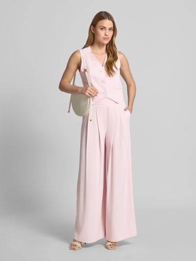 Frauenmodel trägt Stoffhose mit französischen Eingrifftaschen von Rinascimento, hellrosa, Wide Leg Fit, seitlicher Reißverschluss, Material-Mix, Ganzkörperansicht von vorne.