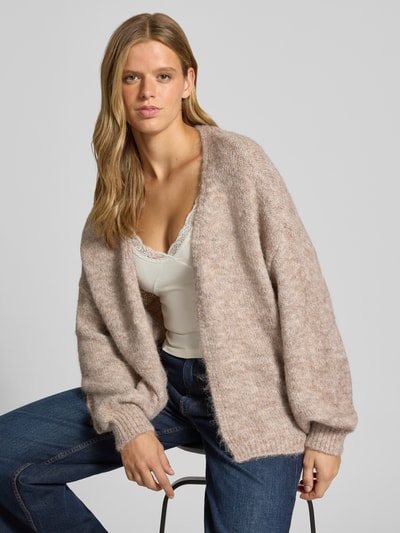 Frauenmodel trägt Regular Fit Strickjacke mit Woll-Anteil Modell 'NELLIE' von ONLY, beige meliert, strukturierte Oberfläche, Nahaufnahme Oberkörper. Damen Strickjacke von ONLY