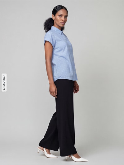 Frauenmodel trägt Weite Hose mit elastischem Bund Modell 'Coralie' von MAC in Schwarz, kombiniert mit hellblauer Bluse, Damen Weite Hose von MAC, Ganzkörperansicht von vorne, KI-modifiziertes Bild.
