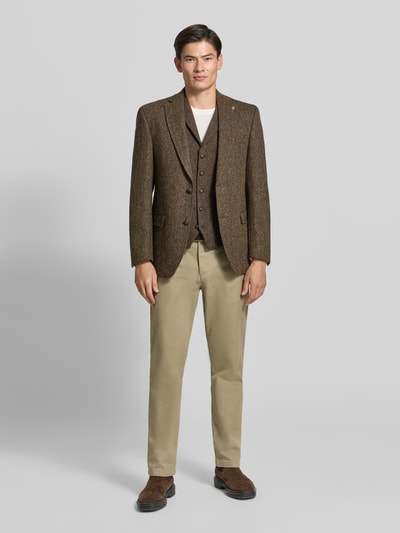 Männermodel trägt Weste mit Brustleistentasche Modell 'Warner' von Carl Gross aus reiner Wolle in Braun, Regular Fit, Ganzkörperansicht von vorne.