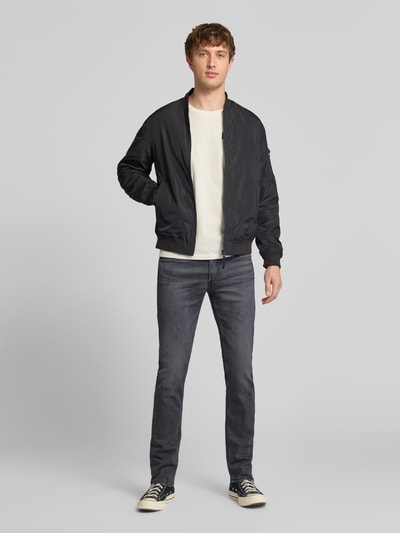 Męskimodel nosi Slim Fit Jeans im 5-Pocket-Design Modell 'Grover' od Replay, mieszanka bawełny z dodatkiem streczu, dopasowany krój, krój regular fit, ciemnoszare odcienie, zapięcie na guzik i zamek błyskawiczny, szerokość w rozmiarze 32/32: 43 cm, długość wewnętrzna nogawki: 83 cm, zdjęcie całej sylwetki z przodu.