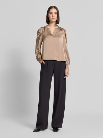 Frauenmodel trägt Langarmbluse mit Stretch-Anteil Modell 'Rosslyn' von Neo Noir in Beige mit V-Ausschnitt, Satin, lockerer Passform, Ganzkörperansicht von vorne.