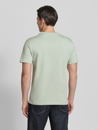 Männermodel trägt T-Shirt mit Logo und Rundhalsausschnitt von Guess aus reiner Baumwolle im Regular-Fit, Rückenlänge 70 cm, Ganzkörperansicht Rückansicht.