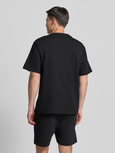 Männermodel trägt T-Shirt mit 1/2-Arm von COLUCCI in Schwarz, gerader Schnitt, reine Baumwolle, Ganzkörperansicht Rückansicht.