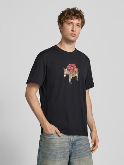 Männermodel draagt t-shirt met motiefprint Model 'DONKEY TAXI' van The North Face in zwart, puur katoen, regular fit, ronde hals, motiefprint, ruglengte maat M 70 cm, logoprint op de achterkant. Ganzkörperansicht van voren.