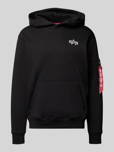 Produktfoto, Hoodie mit Label-Details von Alpha Industries in Schwarz aus Baumwoll-Mix, Kapuze, Reißverschlusstasche am Ärmel, Känguru-Tasche, Gerippte Abschlüsse, Lockerer-Schnitt, Rückenlänge 68 cm, Ärmellänge 67 cm.