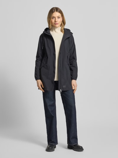 Kobiece model prezentuje Parka mit Label-Patches Modell 'AMETI' od khujo w kolorze czarnym, prosta forma, całkowity widok z przodu.