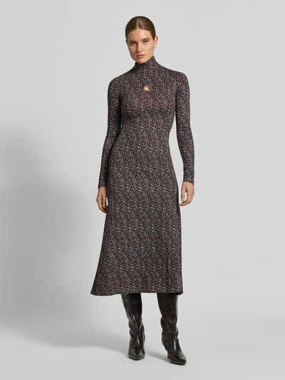 Vrouwenmodel draagt Maxikleid aus Viskose-Mix van Rabanne, mix van viscose en katoen, nauwsluitend model, opstaande kraag, cut-out op borsthoogte, met lange mouwen, totale lengte maat 38: 130 cm, borstwijdte: 39 cm, mouwlengte: 75 cm, geheel bedrukte stof met kleine vormen in zwart, rood en blauw, gladde textuur, geheel lichaam van voren